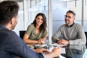 Smiling,Mature,Couple,Meeting,With,Bank,Manager,For,Investment.,Mid