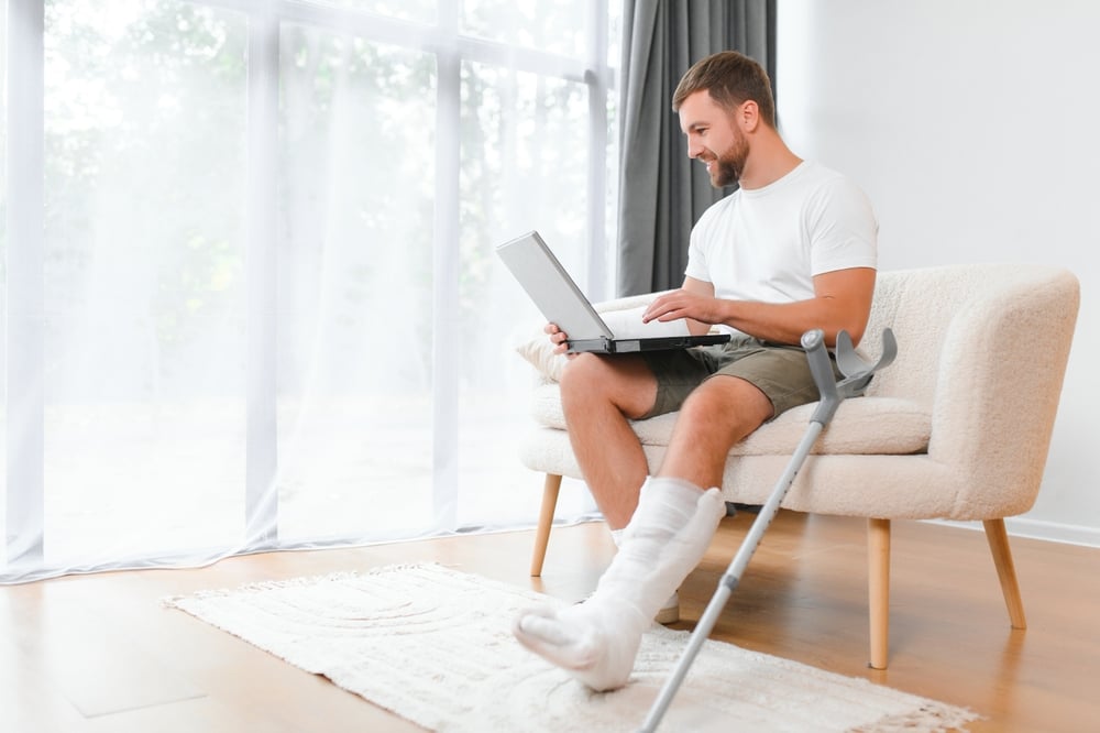 Happy,Young,Man,With,Arm,In,A,Cast,Sitting,On